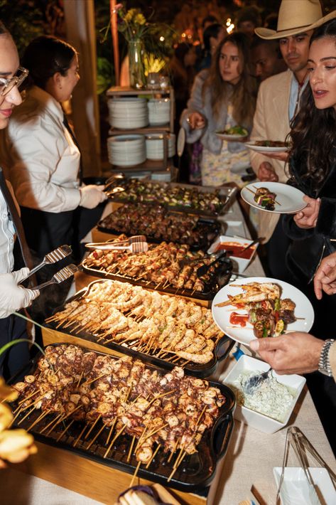 A group of people enjoying various food items from buffet stations. The individuals are seen socializing and having a good time while filling their plates with an assortment of appetizing dishes. The food stations are arranged in a visually appealing manner and showcase a wide range of cuisine options. Live Food Stations, Buffet Stations, Food Stations, Man Food, Big Wedding, Wedding Food, Living Food, The Grill, Wedding Reception