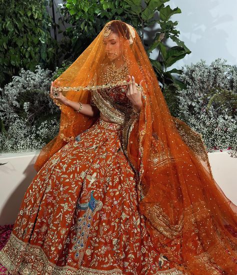 Get ready to be amazed by this stunning burnt orange bridal joda! Inspired by the beauty of lotus flowers and the magnificent peacock, this outfit is a masterpiece of intricate detailing and vibrant colours. The flying peacock motifs not only bring an element of positivity but also exude elegance. Complete with a graceful veil and a border dupatta, this ensemble is a true embodiment of grace and beauty. Style by @devampandeyofficial Jewellery @rang.mahal.jewels White Lehenga With Green Dupatta, Orange Wedding Lehenga Indian Bridal, Orange Lehenga Bridal, Orange Wedding Lehenga, Burnt Orange Lehenga, Orange Bridal Lehenga, Indian Bride Look, Flying Peacock, Dupatta Setting