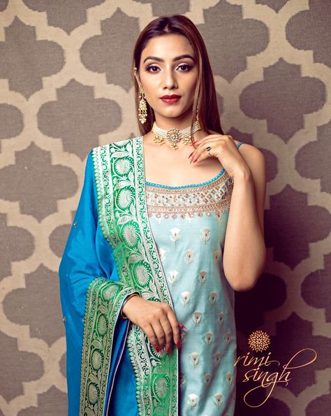 "CHAND COLLECTIVES" Festive Winter 2019 Picture Credits House Ocf Sky blue pure muga banarasi kurta with hand embroidery on the neckline paired with an ink blue cotton silk palazzo and a azure blue chinnon chiffon dupatta with hand embroidered flowers all over. There is banarasi border on the kurta ghera and four sides of the dupatta. Available exclusively at Rimi Singh Studio A 999 Sushant Lok 1 Gurgaon #9818310054 Dupta Design, Sky Blue Suit, Light Blue Suit, Eastern Dresses, Shadi Dresses, Hand Embroidered Flowers, Punjabi Suit, Indian Suits, Chiffon Dupatta