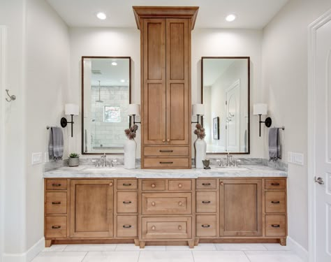 Double Bathroom Vanity With Storage Tower, Updated Jack And Jill Bathroom, Double Vanity Linen Tower, Bathroom Vanity Towel Storage, Primary Bathroom Cabinet Ideas, Master Bath Stained Cabinets, Bathroom Vanity With Tall Cabinet In Middle, Split Vanity With Linen Cabinet, Double Vanity With Linen Cabinet In Middle