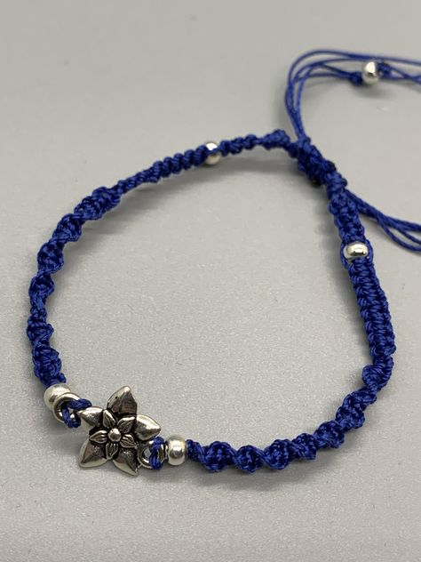 A dainty floral focal charm sets this minimalist woven bracelet apart from the rest.     A one of a kind artisan created dainty navy blue braid of polyester threads and silver tone beads. A simple but striking statement. Navy Blue Jewelry, Dr Marvel, Blue Weave, Woven Bracelet, Saint Augustine, Bracelet Blue, Woven Bracelets, Minimalist Bracelet, Blue Jewelry