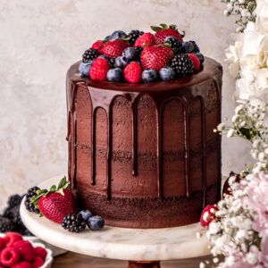 chocolate cake with chocolate ganache drip topped with strawberries, blueberries, raspberries and blackberries. Chocolate Cake Topped With Strawberries, Rustic Chocolate Cake Birthday, Cute Cakes With Strawberries, Chocolate Berries Cake, Chocolate Cream Cake Design, Chocolate Berry Cake Decoration, Chocolate Cake Toppings Decoration, Chocolate Ganache Cake With Strawberries, Chocolate Cake Decoration With Fruit