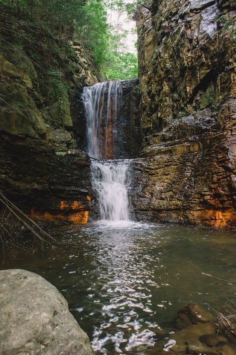 A waterfall makes its way between two rock walls, carving out a wide path for the water to take. Two levels of falling water, orange and brown rocks everywhere. A beautiful peaceful landscape photo. Copperhill Tennessee, Tennessee Waterfalls, Mountains Aesthetic, Fall Break, Knoxville Tennessee, Morgan Wallen, East Tennessee, Summer Bucket Lists, Summer Bucket