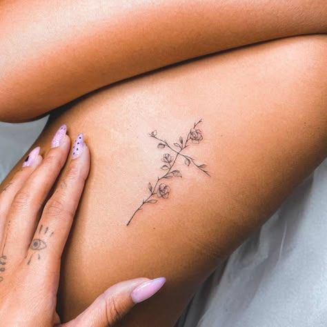 Fine line flower cross tattoo on the rib. Flower Cross Rib Tattoo, Christian Fine Line Tattoos For Women, Beautiful Cross Tattoos, Small Cross With Flowers Tattoo, Flower Cross Tattoos For Women, Rib Cross Tattoos For Women, Cute Cross Tattoos For Women, Elegant Cross Tattoo, Spine Tattoos For Women Cross