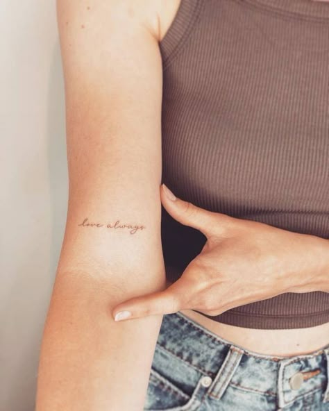 Small Cursive Tattoo On Arm, Inner Elbow Name Tattoo, Writing Bicep Tattoo, Over The Heart Tattoo Placement, Tattoos With The Word Love, Vow Tattoo Ideas, Quote Tattoo On Bicep Women, Inner Arm Writing Tattoos For Women, Cursive Word Tattoos For Women