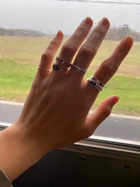 hand with rings painted nails Rings Lesbian Style, Where To Put Rings On Your Fingers, Thumb Rings Aesthetic, Silver Rings Hand, Many Rings On Hand Aesthetic, Rings Stacking Ideas, Lesbian Rings Hands, Hands Full Of Rings, Silver Ring Stacking