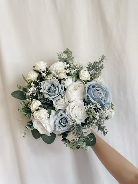 "These beautiful artificial wedding bouquets are made from faux flowers of dusty blue, white and off white, sage greenery and silk eucalyptus. They will make the perfect addition to your big day!  This bridal bouquet consists of white roses, peonies and dahlias with green silk eucalyptus and sage greenery and fillers. The stems are wrapped in twine. The bridal bouquet pictured is 12\" (30 cm). Bouquet Size Available: Bridal Bouquet- 12\" (30 cm) Bridesmaids Bouquet - 8\" (20 cm) Toss bouquet 6\" (15 cm) Matching bridesmaids bouquets, toss bouquet, corsages and boutonnières and other accessories are available." Sage Green And Blue Bouquet, Blue And White Tulips Bouquet, Dusty Blue And Sage Green Bridal Bouquet, Wedding Flowers Blue And Green, Blue And Green Bouquet Wedding, Dusty Blue Wedding Bouquet Brides, Blue White And Greenery Wedding, Blue And Yellow Bouquet, Light Blue Bouquet