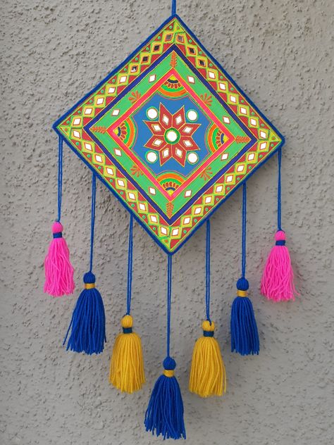 A simple, easy and colorful wall hanging craft idea. I have made it using waste cardboard. Painted it with acrylic colors and decorated with 3D outliners, yarn and some mirrors. This festive season add some colors to your home with this craft idea, its super easy to make. Wall Hanging Painting Ideas Canvas, Wall Decoration Craft Ideas, Cute Wall Hangings Diy, Home Made Wall Hanging, Mirror Work On Cardboard, Wall Hanging From Cardboard, Wall Art With Clay, Wall Hanging Diy Cardboard, Mirror Work Wall Hanging