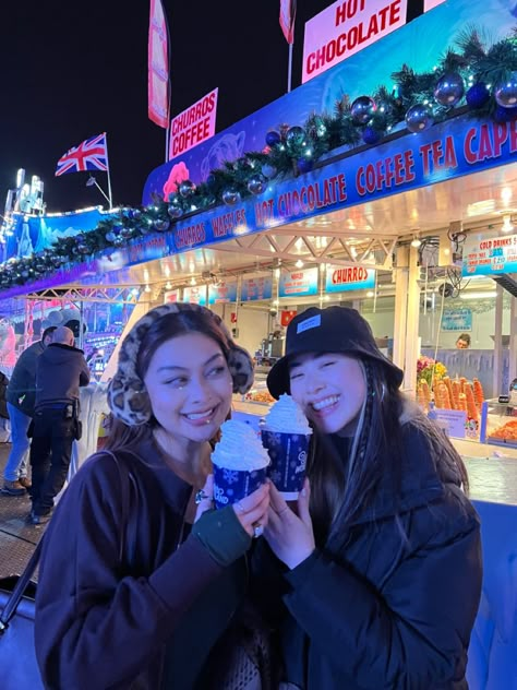 Two Asian girls best friends spending Christmas in winter wonderland holding a hot chocolate and smiling London Christmas Instagram, Winterwonderland London Outfit, Winter Wonderland London Outfit, Christmas Market Instagram Pictures, Winter Photos Friends, London Instagram Pictures Winter, Winter Wonderland Aesthetic London, Winter Wonderland Outfit London, London Pictures Ideas Winter