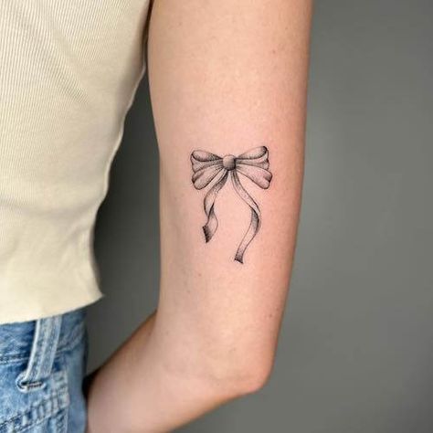 Explore bow tattoo meaning. Discover the symbolic meaning behind bow tattoos and get inspired with our collection of unique bow tattoo designs and bow tattoo ideas. Bow Tie Tattoos For Women, Anchor With Bow Tattoo, Tattoo Ideas For Girls Arm, Bow Tattoo Template, Red Ribbon Tattoo Meaning, Ribbon Tattoos Thigh, Lace Ribbon Tattoo, Small Bow Tattoos For Women, Bow Tattoo Meaning