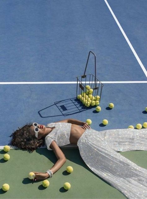 a girl laying on a tennis court with many balls and a basket surrounding her. she is wearing a white flowy set, but the clothes have been edited so they’re white glitter instead. Tennis Fashion Editorial, Vogue Fashion Photography, Sports Fashion Photography, Fashion Photography Editorial Vogue, Mode Tennis, Tennis Court Photoshoot, Lisa Haydon, Tennis Photoshoot, Artistic Fashion Photography