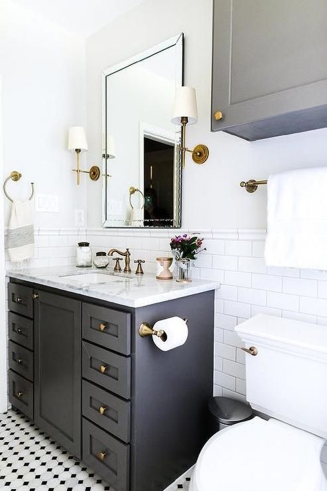 Wonderfully designed black and white bathroom boasts a black bath vanity placed on black and white vintage floor tiles and fitted with brass hardware and a white and gray marble countertop. White Marble Countertops Bathroom, Marble Countertops Bathroom, Half Bathroom Remodel, Gray And White Bathroom, Bad Inspiration, Black And White Tiles, Classic Bathroom, White Marble Countertops, Upstairs Bathrooms