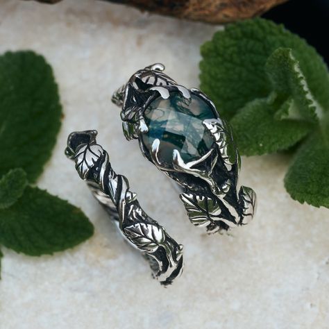 "\"Sierra\" - an alternative, vintage-inspired masterpiece with a floral touch. Crafted in Sterling Silver with Oxidized finishing, detailed leaves, vines, and lines elegantly intertwine around the band, cradling a stunning rose-cut moss agate at the center. The \"Sierra\" statement ring set is the perfect expression for nature lovers and those who appreciate unique jewelry.  Details of Moss Agate Ring \"Sierra\": * 925 Sterling Silver  * Natural Moss Agate * Rose cut Moss Agate: 8mm * Oxidized finishing * 100% handmade work * Express worldwide delivery * Lifetime warranty Details of matching wedding band \"Sierra\": * 925 Sterling Silver  * Oxidized finishing * 100% handmade work * Express worldwide delivery * Lifetime warranty This item needs 10 business days to be shipped. Due to the ha Non Diamond Wedding Rings Silver, Enchanted Forest Wedding Rings, Promise Ring Bands, Wedding Ring Earthy, Forest Wedding Rings, Natural Wedding Rings, Nature Themed Engagement Rings, Forest Ring, Forest Wedding Ring