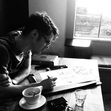 (Open rp) Through the haze of, what can only be described as a dreary Wednesday afternoon, I found myself leaning heavily on the table, in a hole-in-the-wall kind of cafe. I had scattered my notes and my plans all over and I focused on only my writing. I am vaguely aware as you sit across from me and raise a questioning eyebrow. I hide my face in the nook of my elbow and mutter,  "shut up." You raise both arms in defense and say amused, "I didn't say anything...." Man Drinking Coffee Aesthetic, Guy Drinking Coffee Aesthetic, Man Drawing Aesthetic, Nerdy Men Aesthetic, Man Writing Aesthetic, Man Leaning On Table, Leaning On Table Pose Reference, Guy Studying, Reading In Cafe