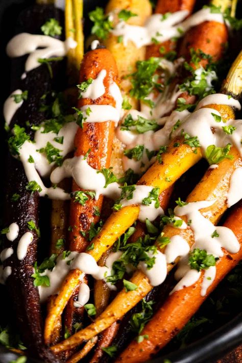 Colorful carrots roasted with spices and topped with a tahini and lemon dressing. Perfect side dish for Thanksgiving to Easter. Gluten free. rnrn#sidedishideas #peelwithzeal peelwithzeal.com Easter Gluten Free, Rainbow Carrot Recipes, Hosting Recipes, Carrots Roasted, Caramelized Carrots, Gluten Free Side Dishes, Gluten Free Recipes Side Dishes, Roasted Rainbow Carrots, Colorful Carrots