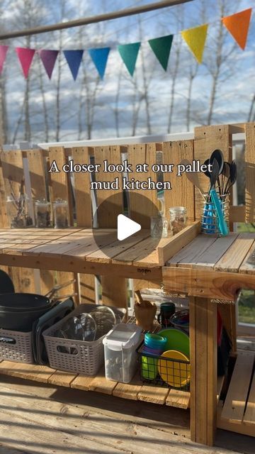 Alicia on Instagram: "The last video of our pallet mud kitchen was very popular and many have asked for building plans!   We don’t have formal plans, but I wanted to offer a closer look at what we built and how we use it to play.   Hopefully this helps you build your own!   We used four free pallets , a few spare pieces of wood for the legs and found the sink for $20 on marketplace.   We keep the blue water jug filled for the kids to use, along with sink stoppers while they play, and buckets underneath to catch the water when they’re finished.  Since our kids are 2 and 3 years old, we kept the height low, but we plan to add longer legs as they grow. Once they’re older, they can hang pots and pans from the top pole, which currently holds the flags (found on Amazon).  The back pallets are br Mud Kitchen Pallets, Pallet Mud Kitchen, Mud Kitchen Ideas, Mud Kitchen For Kids, Free Pallets, Mud Kitchen, Building Plan, Messy Play, Kids Kitchen