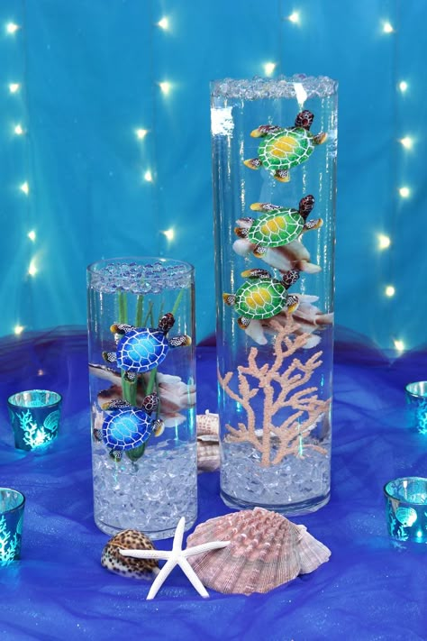 This setup is ideal for creating a captivating sea turtle focal point that embodies the essence of the ocean and adds a magical touch to your event themed decor. Under The Sea Tablescapes, Sea Centerpieces, Ocean Wedding Centerpieces, Sea Turtle Centerpieces, Sea Themed Centerpieces, Underwater Theme Centerpieces, Ocean Themed Table Decor, Ocean Table Decor, Coral Theme Party