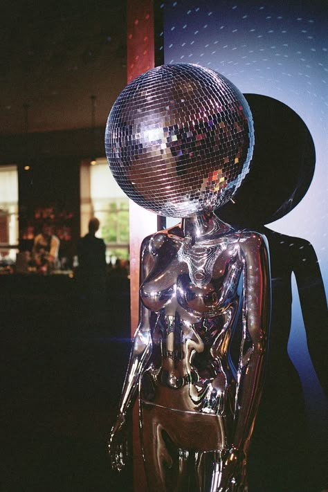 A mirror ball head Disco mannequin prop at a wedding reception room Disco Ball Mannequin, Disco Party Inspiration, Disco Party Props, Disco Ball Sculpture, Modern Disco Aesthetic, Dark Disco Aesthetic, Disco Mannequin, Hedonistic Disco, Disco Ball Decor Party