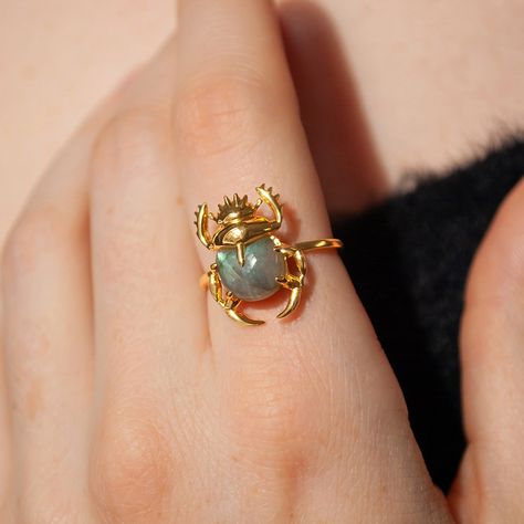 This beautiful ring is made in Sterling Silver and coated with a thick layer of 24K Yellow Gold to a Gold Vermeil thickness and set with a natural Labradorite. 24K Gold Vermeil jewelry is not only hypoallergenic, but it also does not tarnish.  Your ring is meticulously handcrafted and hand-polished to perfection. It is made to last a lifetime with proper care. This is a unique piece of minimalist jewelry for everyday wear.  Please note: Due to the one-of-a-kind nature of the gemstone, exact colors and patterns may vary slightly from the image shown. PLEASE REVIEW THESE INSTRUCTIONS TO LEARN ABOUT HOW TO PROPERLY CARE FOR YOUR JEWELRY.  To properly store your jewelry, store your jewelry in the jewelry bag, and place the jewelry bag in your jewelry box. Doing so will protect and improve the Crystal Rings Gold, Moon Face Ring, Nature Accessories, Layering Rings, Scarab Ring, Yellow Gemstone Ring, Gold And Silver Ring, Handmade Silver Jewellery, Wearable Art Jewelry