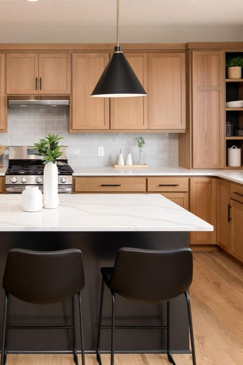 It’s our favorite time of the year! The Spring #ParadeofHomesTC is on now through April 7. 🌷☀️ 🌈  __ Oak cabinets, black kitchen island with black barstools, floating pendants, white countertops, kitchen goals, light wood floors. White Cabinets Wood Island Black Counter, Light Wood Cabinets With Black Island, Oak Wood And Black Kitchen, Black Island Oak Cabinets, Kitchen Wood Cabinets Black Countertop, Black Kitchen Island Wood Cabinets, White Black Oak Kitchen, Black Island White Countertop, Honey Oak Cabinets Black Countertop