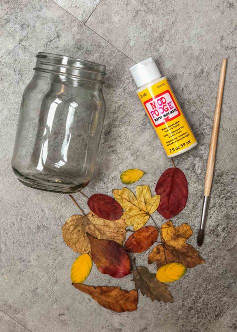 Easy leaf mason jar lanterns nature craft - Growing Family Glass Lantern Diy, Pressed Flower Jars, Crafts With Fall Leaves, Mason Jar Lanterns Diy, Leaf Lantern Craft, Waldorf Festivals, Recycled Candle Jars, Family Christmas Crafts, Leaf Mason Jar Candle