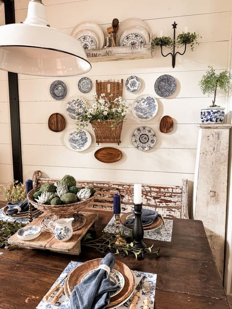 Decorate dining room wall with plate wall decor and vintage basket beside the farmhouse table. Plates And Pictures On Wall, Plates Around Picture On Wall, Decorative Plates On Wall Kitchen, Plates In Frames Wall Decor, Wall Collage With Baskets, Decor Plates On Wall, Decorating With Plates On Wall Ideas, Using Plates As Wall Decor, Dining Room Vintage Decor