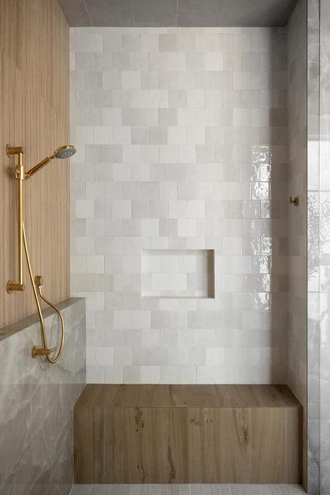 A brown teak shower bench is fixed against gray brickwork square tiles under a gray tiled niche. Bathroom With Sitting Bench, Shower Ledge And Bench, Niche Above Shower Bench, Square Tile Bathroom Walls, Offset Square Tile, Shower Bench Ideas Built Ins, Master Shower With Bench, Tiled Shower Bench, Shower Bench Built In