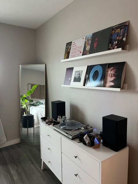 Corner of bedroom with grey floors. Record player on white dresser. Records displayed on wall on while ikea shelves. Gold frame mirror in corner with plant in black plant stand. Wall Decor Bedroom Men Room Ideas, Tv In Room, Street Style Bedroom, Street Style Room, Mens Room Decor, Mens Bedroom Decor, Vinyl Room, Decorating Home, Room Redesign