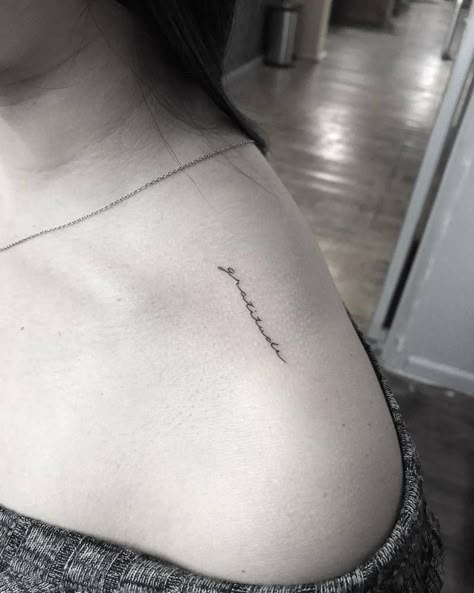 “Gratitude” tattoo on top of the left shoulder. Gratitude Tattoo Ideas, Shoulder Tattoo Words, Gratitude Tattoo, Top Of Shoulder Tattoo, Girl Spine Tattoos, Sacred Tattoo, One Word Tattoos, Skeleton Hand Tattoo, Shoulder Tattoos