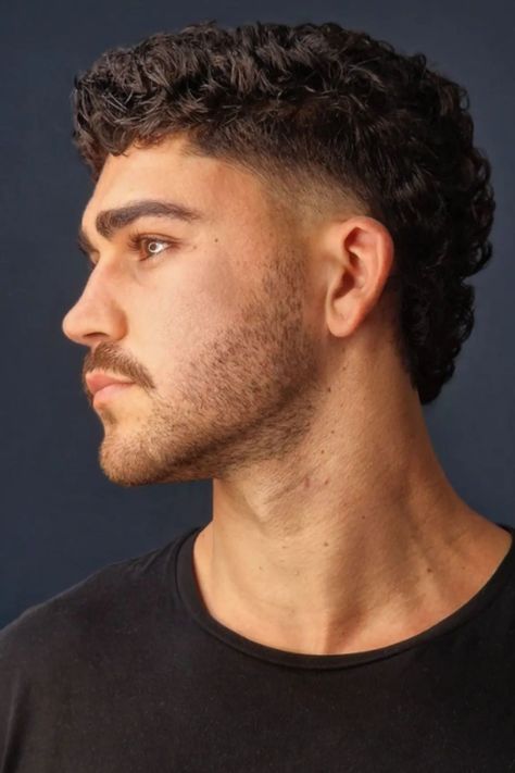 The Best 25 Modern Mullet Haircuts for Men (Detailed Gallery) | Heartafact Haircut For Man Curly Hair, Thick Mullet Men, Men’s Shaved Sides Haircut, Side Quiff Men Hairstyles, Slightly Wavy Hair Men, Buzzcut Mullet Fade, Men’s Modern Mullett, Modern Muller Men, Mid Mullet Fade