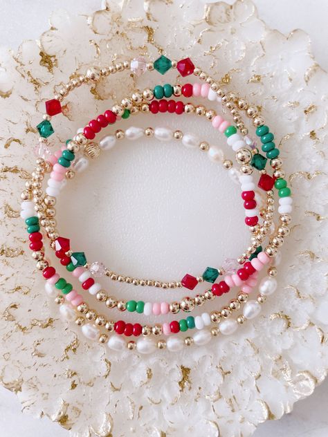 This very dainty Christmas set can be purchased as a set or individually  There are four pieces in this set. Two seed bead and gold filled beads bracelets, one pearl bracelet and Czech (three beads) and gold filled beads. Christmas Glass Bead Bracelet, Christmas Stretch Bracelets, Fun Beaded Bracelets, Diy Holiday Jewelry, Christmas Stack Bracelets, Glass Bead Bracelet Designs, Christmas Bracelets Clay Beads, Bracelet Words Ideas, Holiday Beaded Bracelets