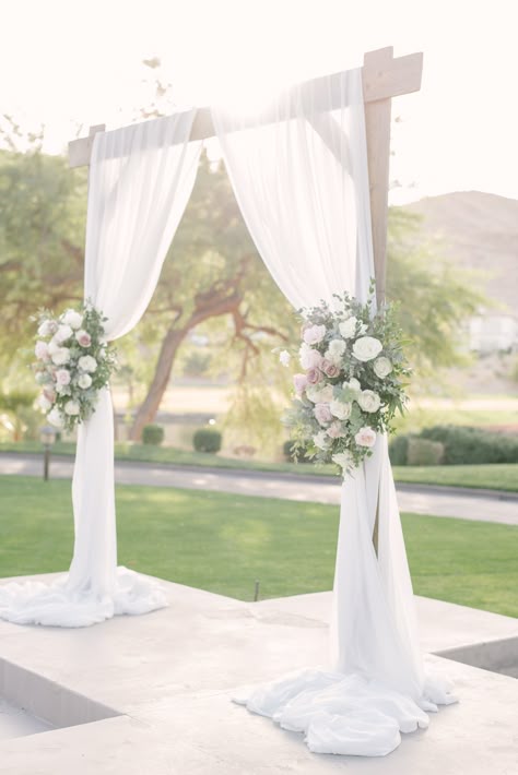 Wooden square wedding arch with white draping and two large spring flower pieces with blush, ivory, and lavender flowers.  Large tree and greenery background.  #lasvegasweddingvenue #woodarch #microweddingslasvegas July Wedding Colors, Flower Arch Wedding, Wood Wedding Arches, Bridesmaid Dresses White, Greenery Bouquets, Wooden Wedding Arches, White Wedding Arch, Wedding Arches Outdoors, Most Beautiful Flower