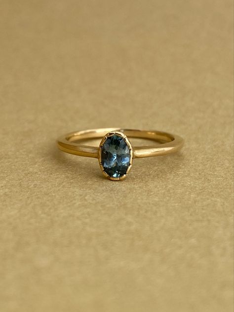 This beautiful, nature-emulating ring features an organic textured bezel-set center teal Montana Sapphire. An exquisite ring for those who appreciate the tranquility of nature, natural beauty, and a sophisticated design aesthetic. The low-profile bezel allows for a multitude of curve, cluster, and v-shaped wedding bands to be comfortably nested. Pretty Wedding Rings, Gold Band Engagement Rings, Montana Sapphire Engagement, Montana Sapphire Engagement Ring, Montana Sapphire Ring, Emerald Ring Vintage, Bezel Engagement Ring, Yellow Jewelry, Engagement Ring Shapes