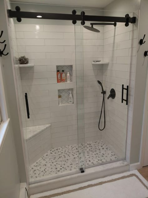 Custom Shower + Cambridge Shower Doors + Black Ladder Pulls + Walk-in Shower + 4x24 White Subway Tile + Merola Backsplash + Shower Corner Bench + Corner Shower Shelves + Black Shower Fixtures + Bypassing Shower Doors + Pebble stone shower floor + Sherwin Williams + Sea Salt + Valspar Ultra Satin Corner Seat Shower Ideas, Small Tiled Walk In Shower Ideas, Shower With Small Bench, Walk In Shower With Shelves, Walk In Shower With Corner Bench, Walk In Shower With Corner Seat, Redoing Shower Tile, Corner Bench Shower Seat, Corner Seat In Shower Ideas