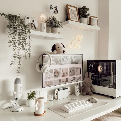 A cozy and inviting home office setup featuring a white desk with modern computer equipment, surrounded by playful decorations including plush toys, hanging plants, and unique neon light art. The walls are adorned with various shelves showcasing more plants, toys, and framed pictures, creating a warm and whimsical atmosphere. Desk Decor Ideas Diy, Cute Desk Decor Ideas, Cute Diy Decor, Cozy Desk Setup, Desk Decor Ideas, Cute Desk Decor, Positive Environment, Handmade Photo Frames, Cozy Desk