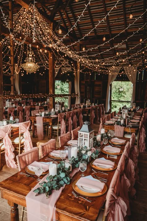 There is something magical about the look and feel of a barn wedding. It is a way to make a formal gathering to also be informal, relaxed, like a family get together. It also seems to make things stand out more, like the chandelier in this photo. Add in the beautiful farmhouse style tables and listen to the compliments. Farmhouse Theme Wedding, Wedding Venue Farmhouse, Wedding In Farmhouse, Farmhouse Decor Wedding, Rustic Princess Wedding, Barnhouse Wedding Rustic, Country House Wedding Decor, Wedding Barn Lights, Rustic Wedding Set Up