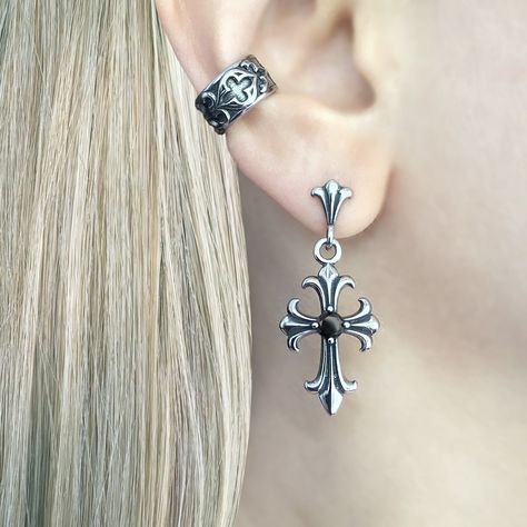 Gothic Cross Earring, a striking piece of jewelry that embodies the essence of gothic style and dark elegance. Crafted with meticulous attention to detail, this earring is designed to make a bold statement and add a touch of mystique to any outfit. Sold as Single or Pair Material : 316 Stainless steel Set with Black and Clear Cubic Zirconia Size: 38 mm long Closure: Butterfly push back Listing for pair of earrings only Elegant Gothic Jewelry, Goth Ear Stack, Elegant Piercings, Moodboard Jewelry, Gothic Moodboard, Gothic Piercings, Goth Piercings, Alt Earrings, Dark Accessories