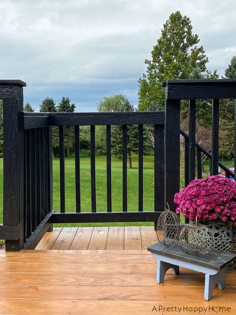 Our deck with black railing is finally done and we love it! Deck With Black Railing Ideas, Black Painted Deck Railing, Stained Deck Black Railing, Black Wood Deck Railing, Black Deck Paint, Black Spindles Wood Railing Deck, Deck Stain Ideas Black Railing, Stained Deck Painted Railing, Wood Deck Black Railings