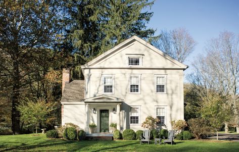 Inspired by 18th century masons, the paint color Harwood Putty CW-5 from Benjamin Moore’s Williamsburg® Paint Color Collection creates the look of a classic whitewashed home exterior. Complemented by a green front door that mimics the lush tress surrounding the home.  House: Harwood Putty CW-5, Regal® Select Exterior High-Build, Low Lustre // Doors: Nicolson Green CW-500, Aura® Grand Entrance®, Satin. Williamsburg Paint Colors Benjamin Moore, Harwood Putty Benjamin Moore, Historic Home Exterior Paint Colors, Colonial Exterior Paint Colors, Colonial Revival Exterior, Cape Exterior, Benjamin Moore Historical Colors, Vernacular House, Wallpaper Staircase