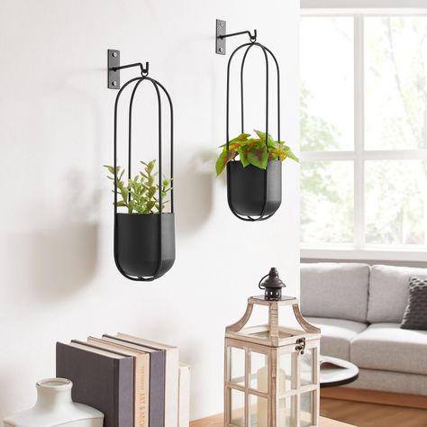 Summer home decor just got better with these stunning wall planters! Meet the Walter 2-Piece Modern Black Metal Oval Hanging Planter Set. Say goodbye to bare and boring walls, and hello to these modern planters. Hang them in your living room, bedroom, kitchen, or garden to add some greenery! #danyabhome #homedecor #interiordesign #homestyle #interiorinspo #wallplanters #modernhomedecor #modernminimalism Metal Hanging Planters, Hanging Frames, Hanging Planter, Wall Planter, Oval Frame, Hanging Planters, Outdoor Shade, Wall Hooks, Black Metal