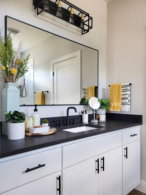 Guest Bathroom Ideas Black Countertop, Black And White Cabinets Bathroom, Boho Bathroom Black Countertop, Black Counter Bathroom Decor, White Vanity Dark Countertop, Bathroom Interior Design Dark Countertop, Black Countertop Bathroom Decor, White Bathroom Cabinets With Black Countertops, Bathroom With White Cabinets And Black Countertop