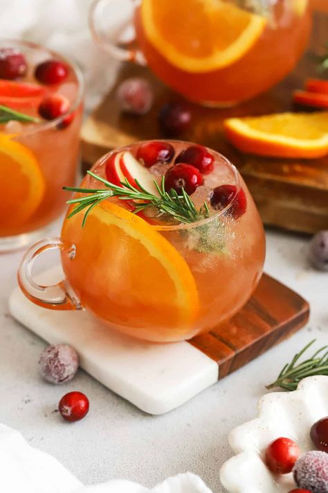 A bright combination of seasonal flavors & fizz, this classic non-alcoholic holiday punch recipe is a fun holiday drink everyone can enjoy! Made without alcohol, this family-friendly Christmas punch has fresh, delicious flavor and can easily scale up to serve a crowd! Choose from individual servings, pitcher, or a large punch bowl sized batch of this easy holiday punch for your next Christmas party! Get the recipe and more holiday mocktail recipes to try at Sweets & Thank You Non Alcoholic Punch Christmas, Non Alcoholic Christmas Punch Recipes, Host Christmas Party, Christmas Non Alcoholic Punch, Batch Mocktail Recipe, Christmas Mocktails Non Alcoholic Easy, Brunch Punch Non Alcoholic, Holiday Mocktail Recipes, Christmas Party Drinks Nonalcoholic