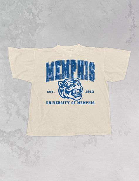 **Officially licensed with the University of Memphis** Show the love for your favorite team in our one and only Memphis University Tigers oversized 90's t-shirt. - Features Memphis in all caps above the official Memphis Tigers logo and est. 1912 to the side, University of Memphis below all in a blue and white ink - Screen print transfer that is heat pressed onto each tshirt - Tshirt is a super soft vintage wash that gets softer after each wash- Oversized fit- Sizing translation: XS/S - L , S/M - XL , L/XL - 2XL , 2XL/3XL - 3XL - Model is 6'1" wearing a size S/M * colors may vary slightly due to screens and filters * University Tees Design, Vintage College Tshirt, Alumni Tshirt Design Ideas, Vintage College Aesthetic, University Shirt Design, College Tshirt Designs, 90s Tshirt Design, College Team Shirts, College Shirt Design