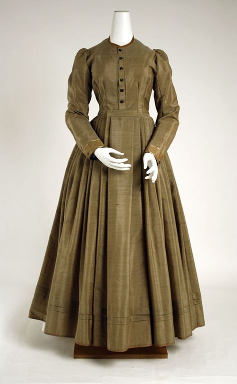 As we can see this gown seems very simple and plain. This is most likely due to being in the middle/lower class. The dress is made from a cotton material and had a few buttons don the middle of the bodice. With a simple neckline and long sleeves, there most likely has a tight fitted bodice, skirt, chemise, bustle, and corset cover underneath the plain gown. 1800s Clothing, 19th Century Dress, 1870s Fashion, 19th Century Clothing, Historical Clothes, Victorian Dresses, 1800s Fashion, Historical Dress, Historic Fashion