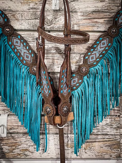 This dark roughout headstall features a bold, contrasting turquoise buckstitch edge and coral, white, bronze, and turquoise beading inlay. It features handsome copper concho accents at each screw bit end. Adjustable at the cheeks and throatlatch for the perfect fit. Dark roughout leather Turquoise buckstitching Colorful beaded inlay Antiqued copper concho screw bit ends 19" - 23" Cheeks; 15" Brow; 2" Wide cheek Headstall and Breast Collar sold separately DS Horse Stuff Western, Western Horse Tack Sets, Breast Collars For Horses, Western Horse Tack Turquoise, Western Tack Sets, Barrel Racing Tack Rodeo, Horse Tack Accessories, Horses Tack, Horses Stuff