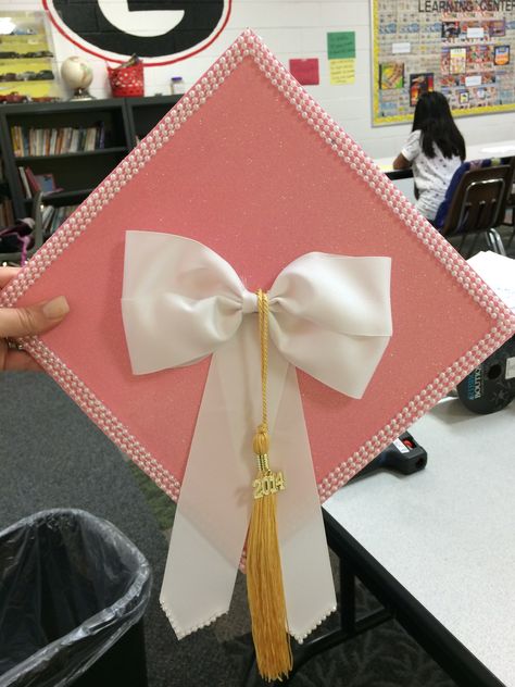 Graduation cap Cute Cap Designs, Caps And Gowns Decoration, Pearl Cap Graduation, Grad Caps With Bows, Esthetician Grad Cap, Graduation Cap Ideas Simple, Graduation Cap Designs With Pearls, Pink Cap For Graduation, Simple Graduation Cap Ideas College