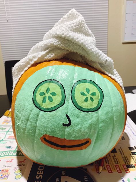 Medium sized pumpkin with green face mask and cucumber eyes, topped with a wrapped towel covering the stem. Halloween Pumkin Ideas Paint, Pumpkin Face Mask Paint, Self Care Pumpkin Painting, Yellow Painted Pumpkin Ideas, Facial Pumpkin Painting, Pumpkins Painting Ideas Cute, Avocado Pumpkin Painting, Cool Halloween Pumpkin Painting Ideas, Fun Carved Pumpkins