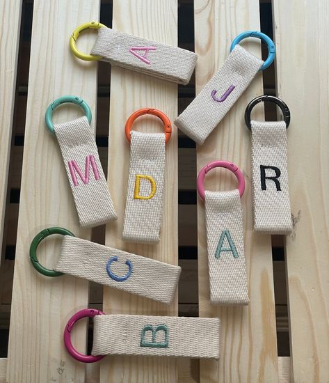 Show off your personality with this personalized embroidered keychain. Perfectly crafted with heavy-duty cotton webbing and a durable metal ring, you can customize the color of both the letter and ring to suit your style. Make a timeless statement with this unique accessory. customize yours! Only one letter per keychai Embroidered Keychains, Diy Projects To Make And Sell, Letter Keychain, Hand Beaded Embroidery, Embroidered Letters, Crewneck Sweaters, Diy Bags Patterns, Diy Tote Bag, Rug Bag