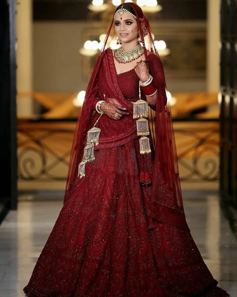 It’s a timeless piece that just never goes out of style. Jewelry With Red Lehenga, Maroon Bridal Lehenga Pakistani, Maroon Chooda Designs Brides, Lehnga Designs 2023, Pakistani Bride Makeup, Maroon Lengha, 2023 Lehenga, Latest Lehnga Designs, Red Lehenga Bridal