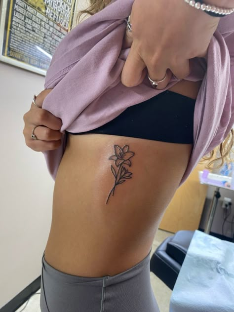 Tiny Lily Flower Tattoo, Hip Lily Tattoo, Lily Flower Rib Tattoo, Tattoo Ideas Female Lily Flower, Lilly Name Tattoo, Flower Bouquet Tattoo Hip, Lower Side Stomach Tattoos Women, Daylillies Tattoos, Tattoo Of Lily Flower